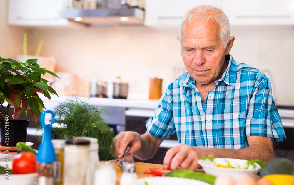 Senor man preparing fresh vegetable salad at home in the kitchen Senor man preparing fresh vegetable salad at home in the kitchen