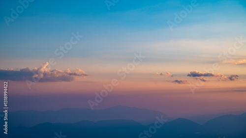 Beautiful clouds at sunset over mountains, rays of sunshine, beautiful light, natural background, calm and tranquility