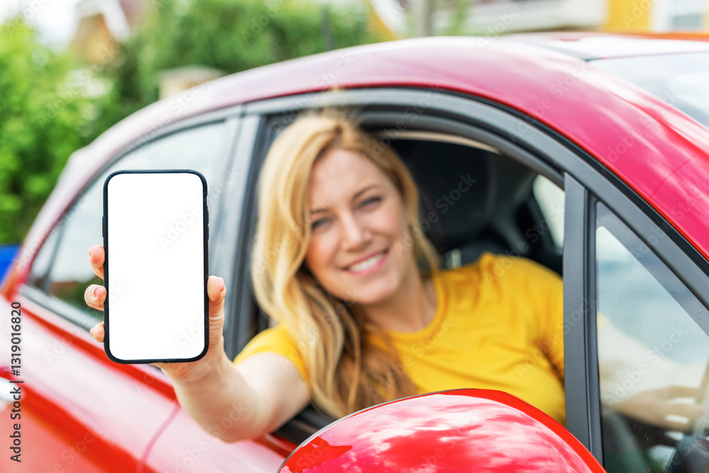 A smiling woman sitting in a red car extends her arm out of the window, holding a smartphone with a blank white screen, ready for customization or advertisement.