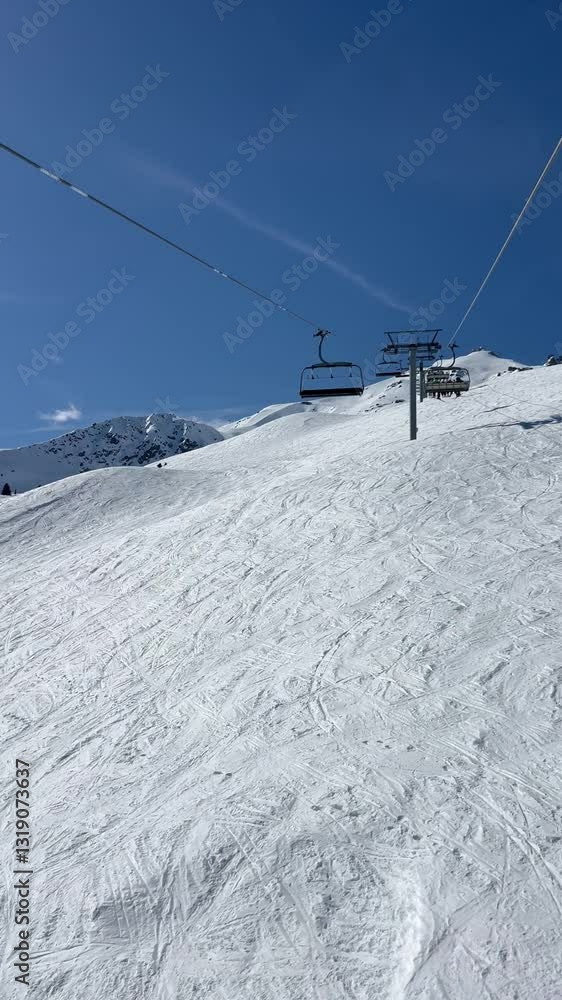 Skiers going up to ski on a ski lift over the slopes of Courchevel ski resort Skiers going up to ski on a ski lift over the slopes of Courchevel ski resort