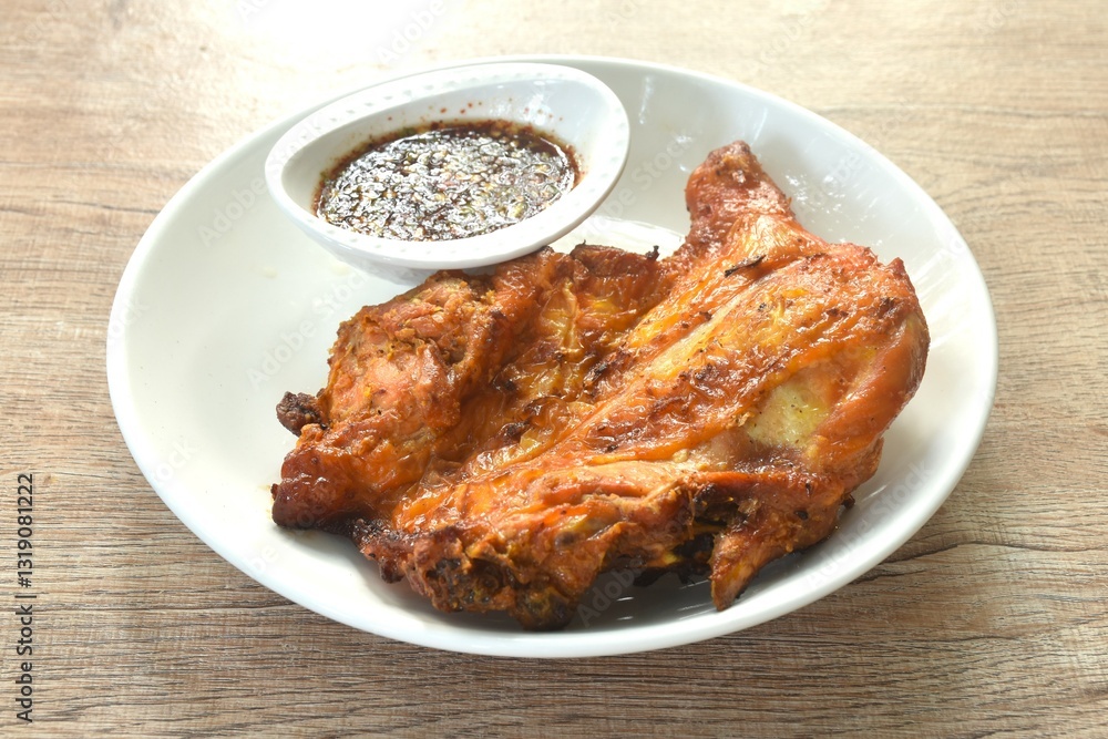 grilled chicken tight stabbing wooden stick on plate dipping with spicy sauce 