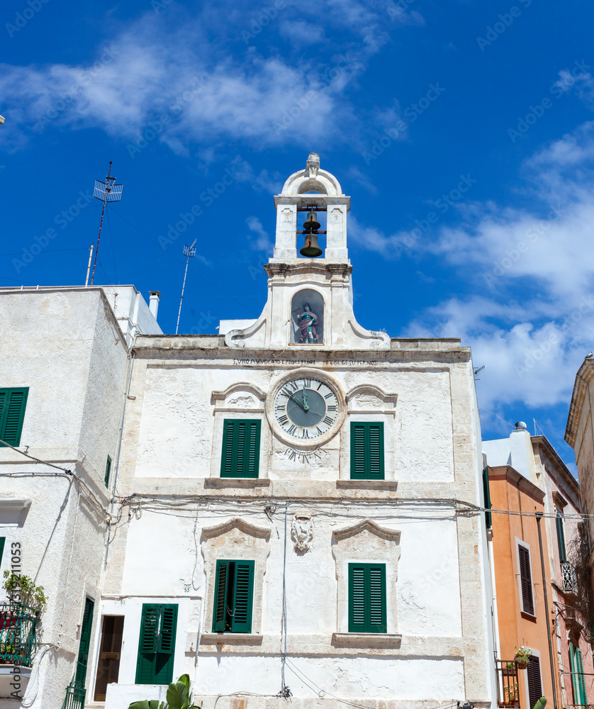 Fototapeta premium Medieval Palazzo dell'Orologio with a 19th-century rope clock in place of a sundial along with a statue of Polignano's patron saint, San Vito, and a bell tower.