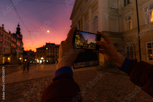 Female hands holding smartphone and making photos in Lviv
