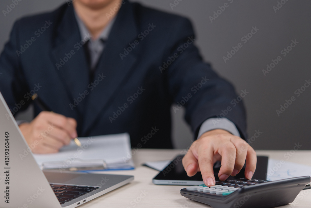 businessman working using a calculator and reviewing financial documents. accounting, financial analysis, budget planning, and business tax, finance management, and strategy investment planning. businessman working using a calculator and reviewing financial documents. accounting, financial analysis, budget planning, and business tax, finance management, and strategy investment planning.