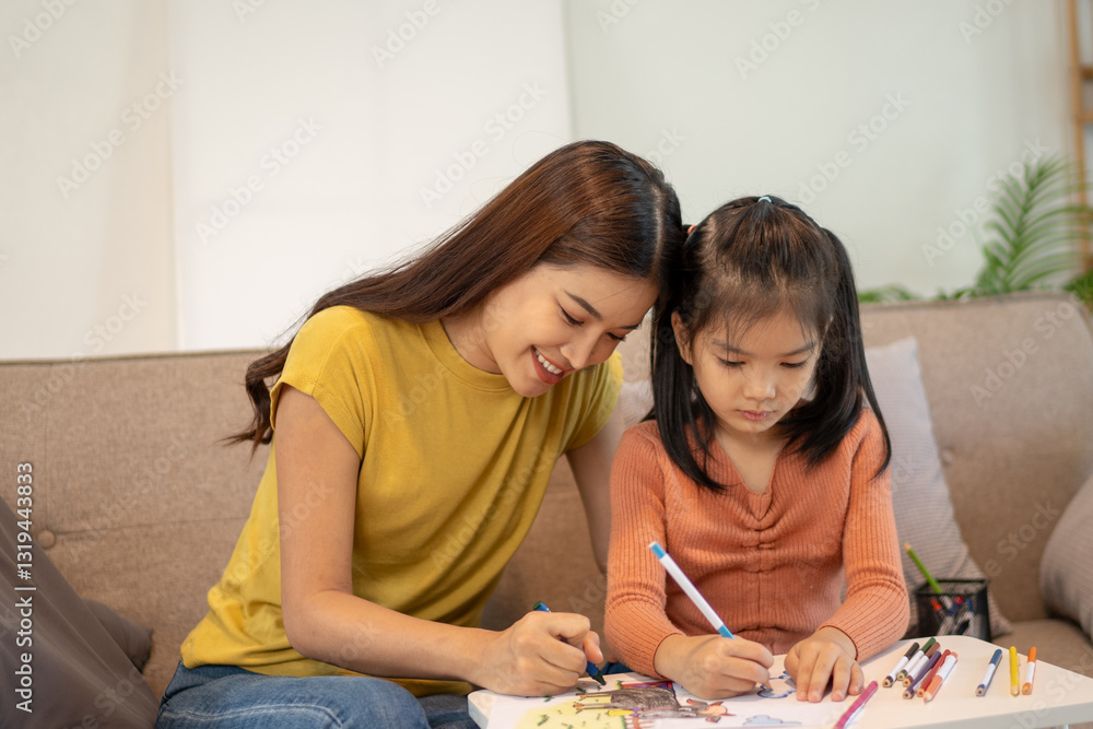 Lovely mom and little young daughter spending time together in their living room. Lovely mom and little young daughter spending time together in their living room.