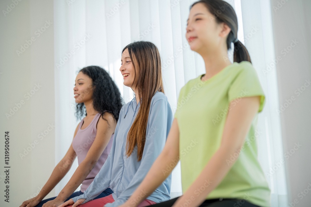 Group of women practicing mindfulness and meditation in a bright, serene studio during a yoga session Group of women practicing mindfulness and meditation in a bright, serene studio during a yoga session