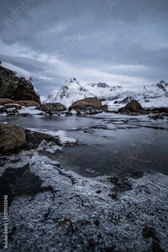 Wallpaper Mural Serene winter landscape with snow-covered mountains and partially frozen water in the foreground Torontodigital.ca