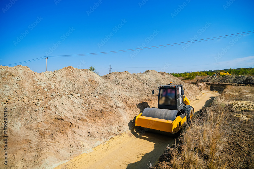 Construction roller that compacts sand on a construction site for laying large-diameter plastic pipes. Construction roller that compacts sand on a construction site for laying large-diameter plastic pipes.