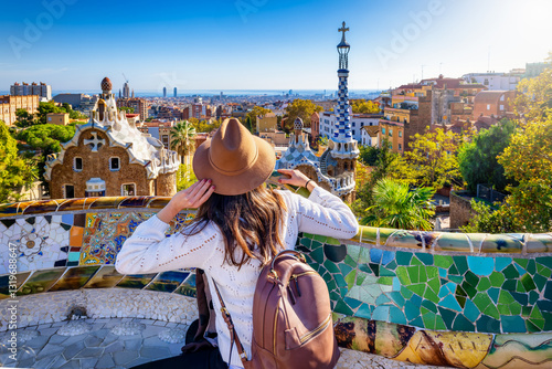 A tourist woman enjoys a sightseeing trip of the famous Park Güell in Barcelona, Spain, on a sunny day