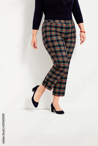 Red and black checkered pants for women’s paired with black full sleeve top and black heels with white background