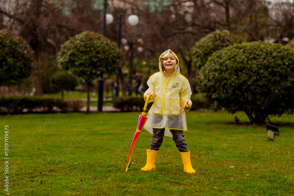 A little, beautiful girl, walking in the rain.in a raincoat with an umbrella A little, beautiful girl, walking in the rain.in a raincoat with an umbrella