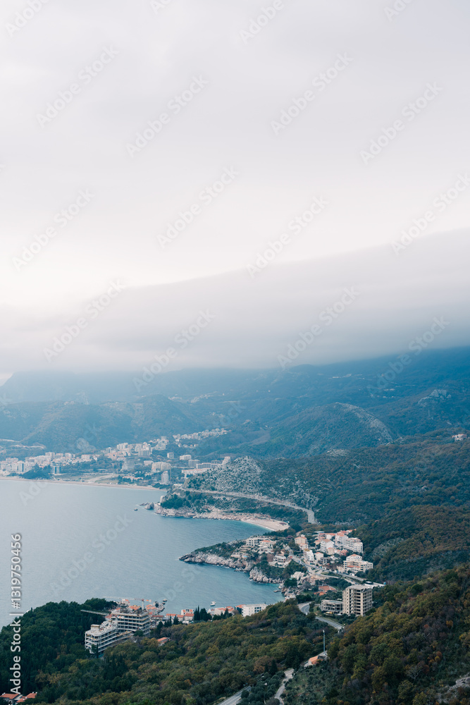 Multi-storey houses on the resort coast at the foot of the mountains in the fog Multi-storey houses on the resort coast at the foot of the mountains in the fog