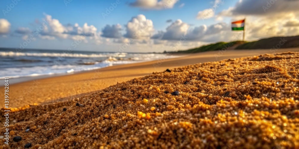 Golden sandy beach with waves and a flag in the background during a serene time at sunset