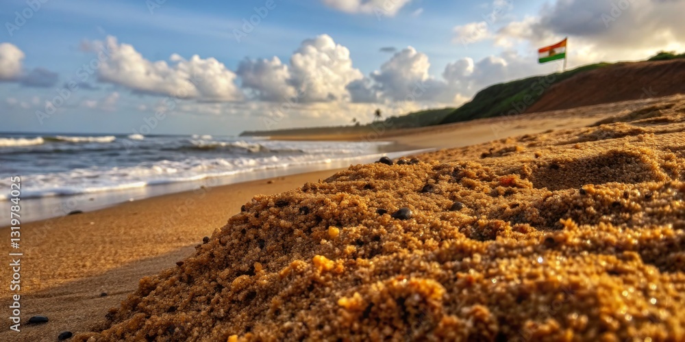 Beautiful sandy beach with clouds and an Indian flag waving in the breeze during sunset