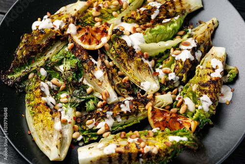 Foto Grilled little gem lettuce with aioli sauce, roasted pine nuts and chilli flakes