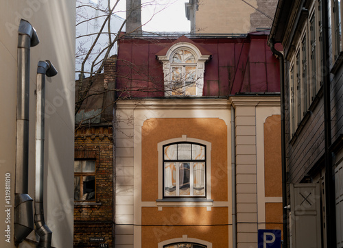Art nouveau style narrow street and single side building in Riga Latvia, inside neighborhood center buildings in orange color and old steel plate roof, sunny day in Riga for apartment owners