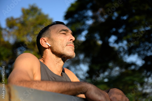 middle aged man breathing fresh air and relaxing outdoors after workout