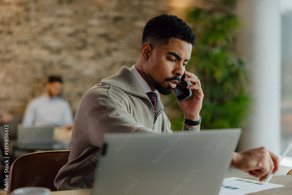 Focused Professional Working on a Phone Call in a Modern Office Focused Professional Working on a Phone Call in a Modern Office