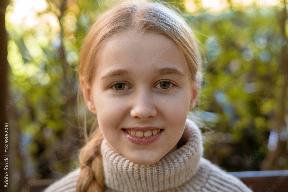 Close-up portrait of a smiling blonde preteen girl with braided hair, wearing a beige knitted turtleneck sweater, in a blurred park background, enjoying a sunny day Close-up portrait of a smiling blonde preteen girl with braided hair, wearing a beige knitted turtleneck sweater, in a blurred park background, enjoying a sunny day