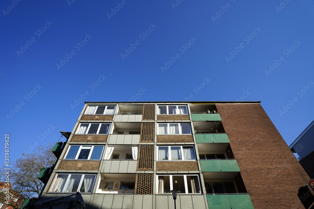 Wohnhaus mit Klinkerfassade und Balkon im Stil der Architektur der Nachkriegszeit vor blauem Himmel im Sonnenschein an der Hansaallee im Hafenviertel oder Hansaviertel im schönen Münster in Westfalen Wohnhaus mit Klinkerfassade und Balkon im Stil der Architektur der Nachkriegszeit vor blauem Himmel im Sonnenschein an der Hansaallee im Hafenviertel oder Hansaviertel im schönen Münster in Westfalen