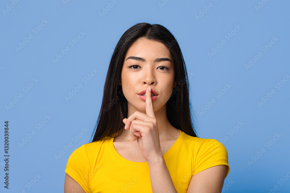 Shhh. Mysterious young asian lady showing keep silence sign at camera, beautiful korean female making hush gesture, holding index finger near lips, posing over purple studio background, copy space Shhh. Mysterious young asian lady showing keep silence sign at camera, beautiful korean female making hush gesture, holding index finger near lips, posing over purple studio background, copy space