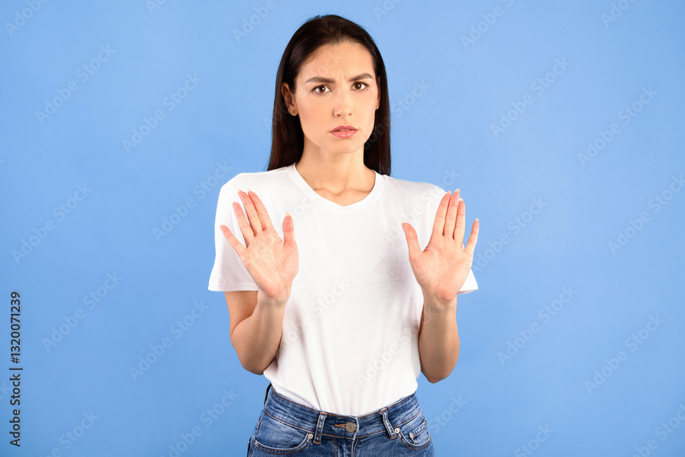 Stop Concept, Thank You But No. Portrait of serious lady making stop hand gesture, isolated on blue studio background. Displeased woman in fear showing denial sign with two palms to camera Stop Concept, Thank You But No. Portrait of serious lady making stop hand gesture, isolated on blue studio background. Displeased woman in fear showing denial sign with two palms to camera
