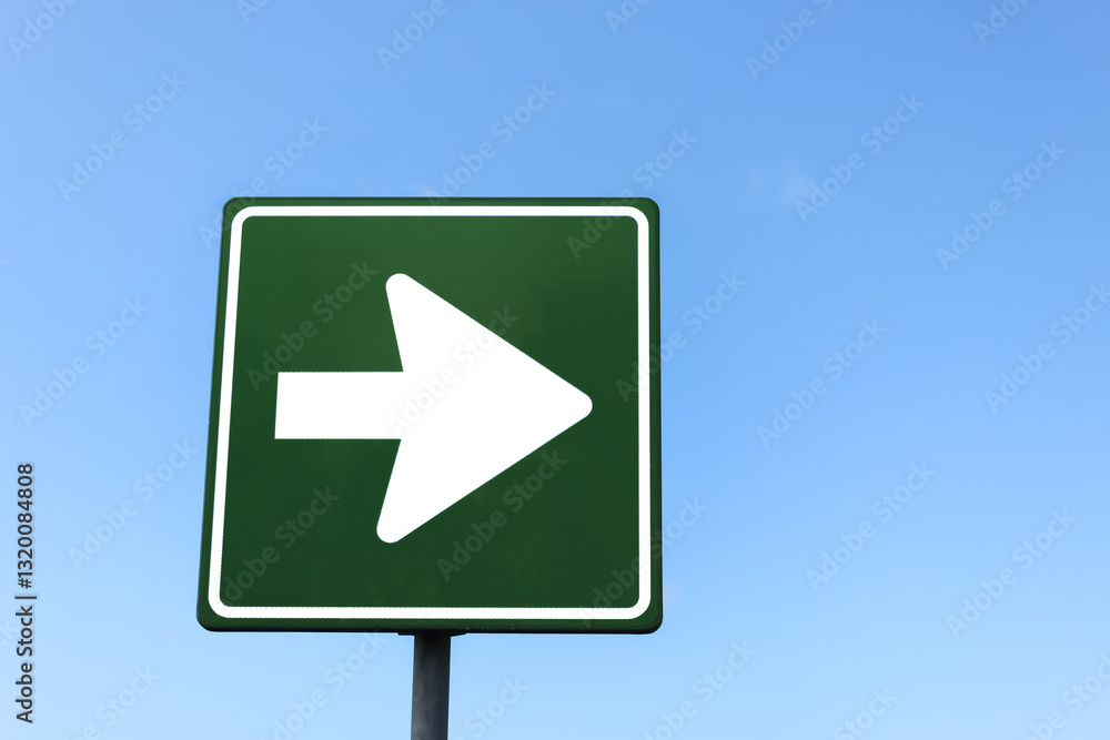 close-up of a green and white straight arrow sign against a blue sky with clouds. used for traffic and wayfinding purposes. where to go. journey or path. turn right here. close-up of a green and white straight arrow sign against a blue sky with clouds. used for traffic and wayfinding purposes. where to go. journey or path. turn right here.