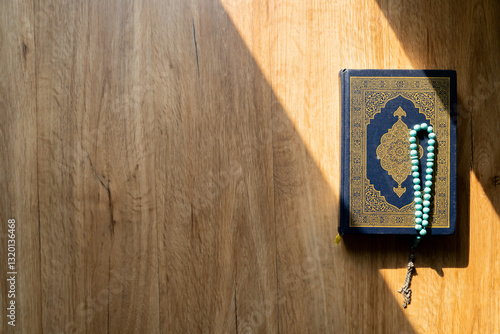 Islamic concept - The Holy Al Quran with written Arabic calligraphy meaning of Al Quran and rosary beads or tasbih, Arabic word translation: The Holy Al Quran (holy book of Muslim) 