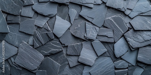 A close-up view of dark slate stones arranged in a layered pattern, showcasing their unique textures and colors.