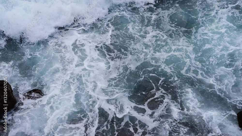 Waves crash against the rocks on the beach, sea spray in the air, sunlight reflects on the water. The natural movement of ocean waves hitting an uneven stone shore. travel, and atmosphere. 4K video. Waves crash against the rocks on the beach, sea spray in the air, sunlight reflects on the water. The natural movement of ocean waves hitting an uneven stone shore. travel, and atmosphere. 4K video.
