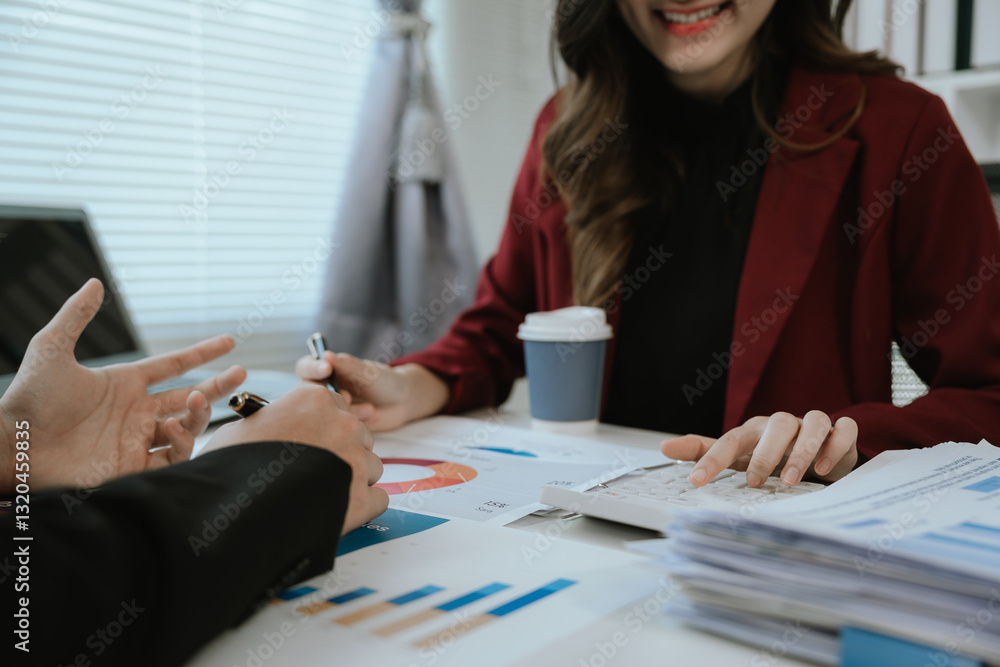 Team of corporate professionals working together in modern office to analyze financial charts and business reports. Businesswoman leading strategic discussion. Team of corporate professionals working together in modern office to analyze financial charts and business reports. Businesswoman leading strategic discussion.