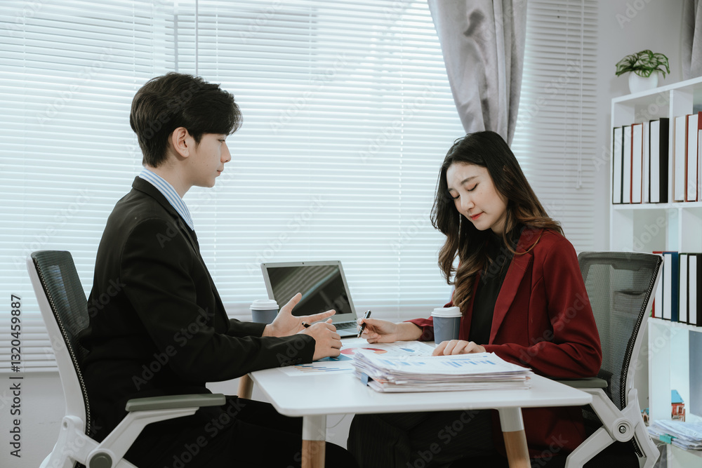 Fototapeta premium Team of corporate professionals working together in modern office to analyze financial charts and business reports. Businesswoman leading strategic discussion.