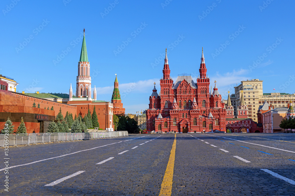 Fototapeta premium Red Square in Moscow, Russia, with the Kremlin walls and the State Historical Museum under a clear blue sky. The iconic cobblestone square is a famous landmark and a UNESCO World Heritage site