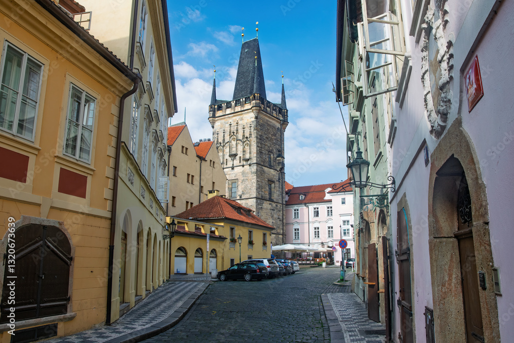 Fototapeta premium Jindrisska Tower standing tall over the charming cobblestone streets and colorful buildings of Prague, Czech Republic, on a clear sunny day