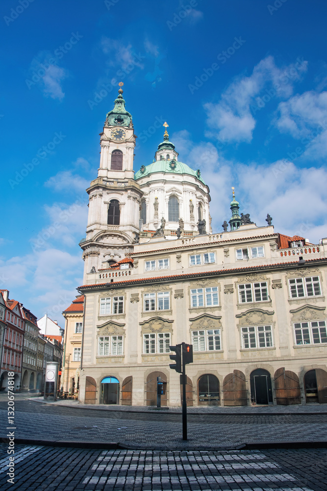 Low angle view of St. Nicholas Church in Prague, Czech Republic, highlighting its baroque architecture against a vibrant blue sky Low angle view of St. Nicholas Church in Prague, Czech Republic, highlighting its baroque architecture against a vibrant blue sky