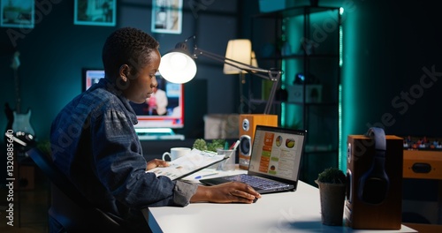 Foto Entrepreneur working from home, using laptop, writing notes on paper