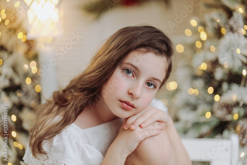 Studio portrait of a delicate 10-year-old girl in a festive Christmas setting