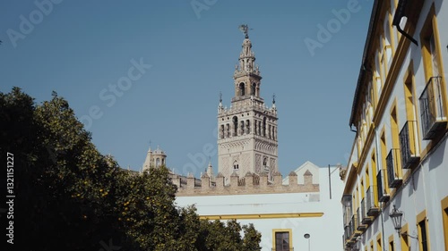 The iconic Giralda tower standing tall amidst a courtyard of orange trees, with the Cathedral in view