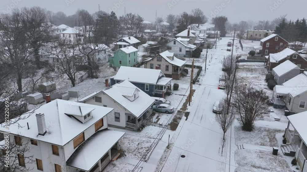 Quiet american housing area with snow-covered roofs in suburb district. Aerial approaching flyover. Cloudy day with snowstorm. Parking cars on street. Falling flurries in winter. Virginia, America. Quiet american housing area with snow-covered roofs in suburb district. Aerial approaching flyover. Cloudy day with snowstorm. Parking cars on street. Falling flurries in winter. Virginia, America.
