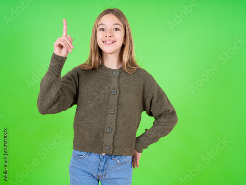 beautiful teen girl wearing green sweater pointing finger up and looking inspired by genius thought, showing good idea sign, having clever solution in mind
