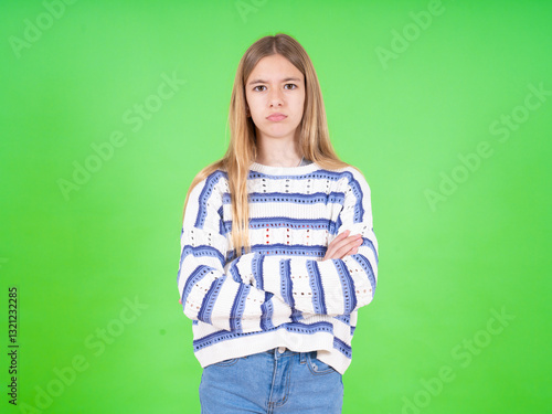 Fotografie Gloomy dissatisfied beautiful teen girl wearing striped sweater looks with miser