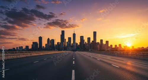 Sunset over a city skyline with empty highway in the foreground