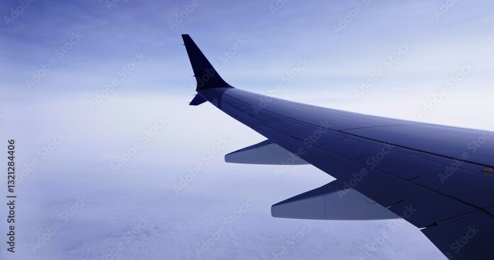 Fototapeta premium Wing of an airplane cruising above the clouds
