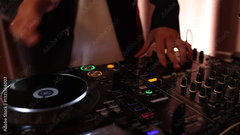 DJ playing music on the console at a disco