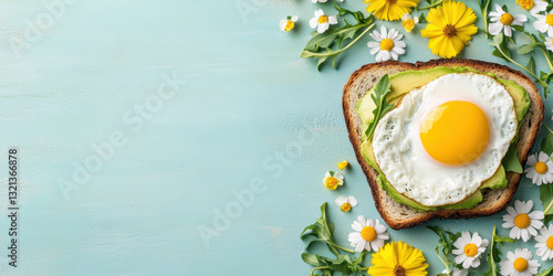 Fast food, Avocado toast topped with a fried egg, surrounded by fresh flowers on a light blue background.