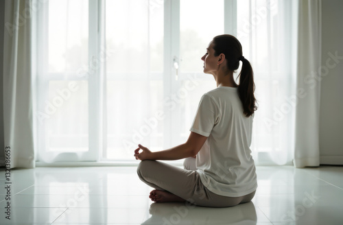 Free Download Woman sitting meditating in white room.  - GFXLoad