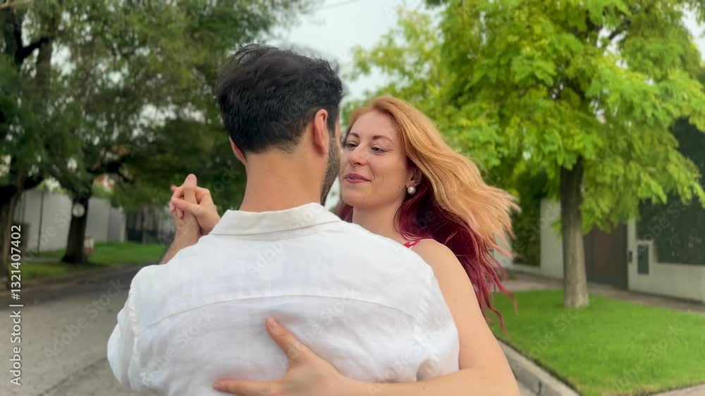 cheerful mid adult man and woman dancingon suburban street on summer day cheerful mid adult man and woman dancingon suburban street on summer day