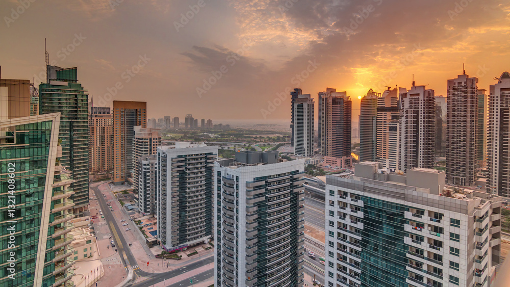 Obraz premium Sunrise view of various skyscrapers and towers in Dubai Marina from above aerial timelapse
