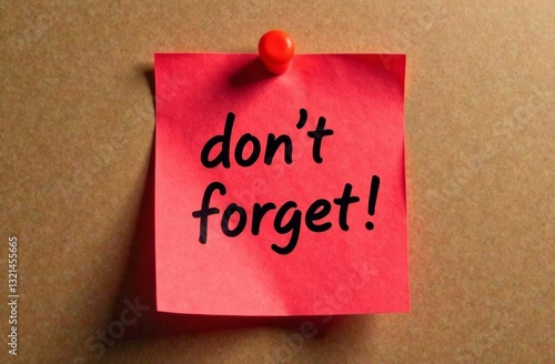 A bright pink sticky note is pinned to a corkboard featuring the message don't forget! in bold black letters serving as a reminder for important tasks or events.