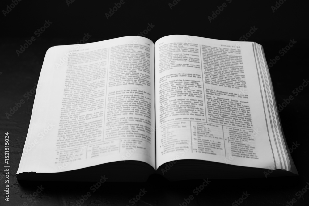 Open Holy Bible in English language on black table, closeup Open Holy Bible in English language on black table, closeup